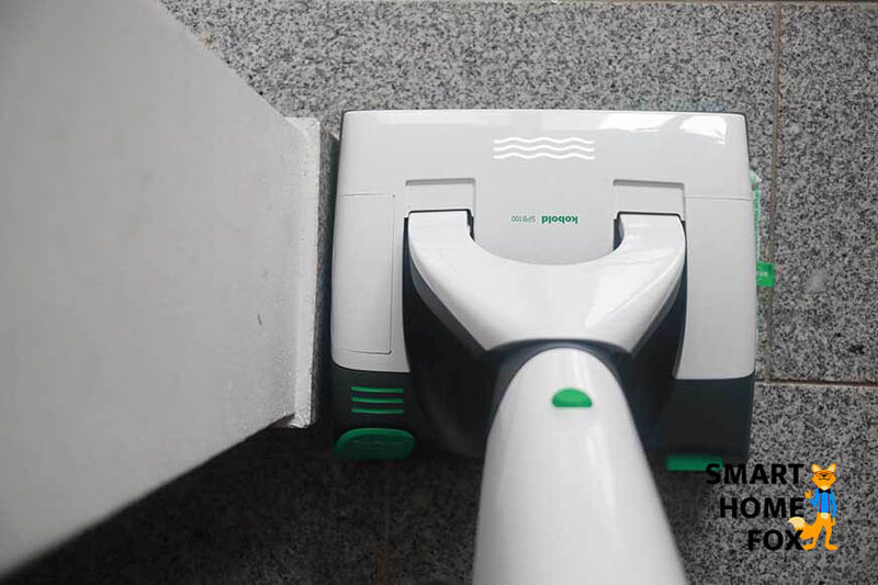 Man sieht, wie eine Kante mit dem Vorwerk Kobold VB100 mit SPB100 Wischaufsatz gereinigt wird.